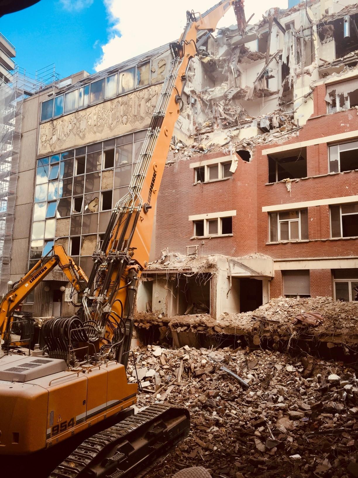 La démolition par Quadrex à Paris Pelle démolissant un batiment à Paris
