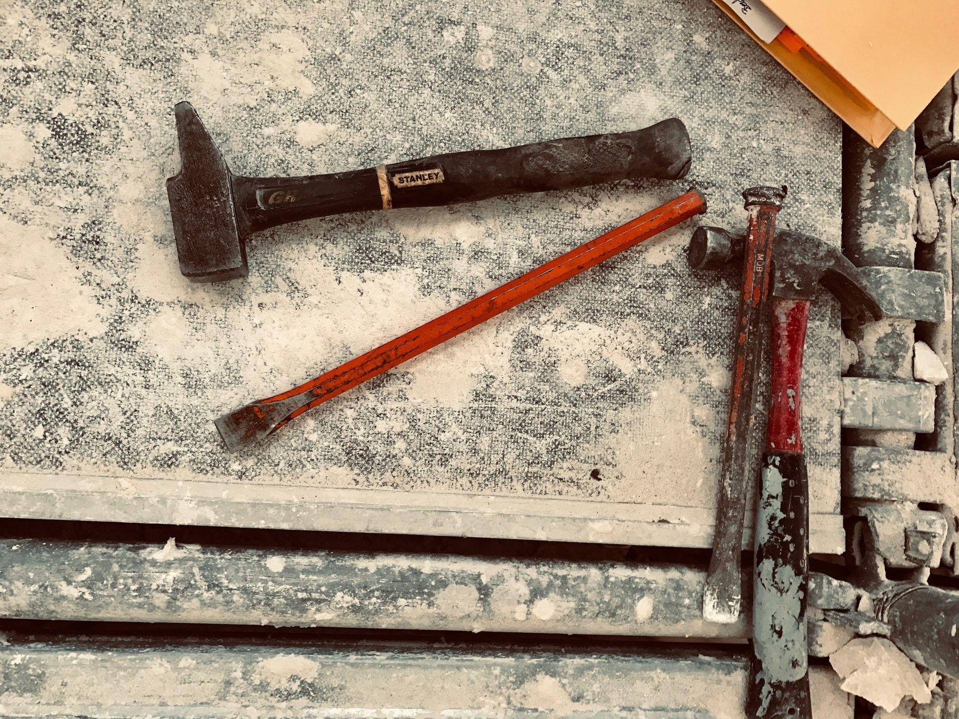 Les outils d'un compagnons démolisseur : marteau, burin, pince coupante sur un échafaudage